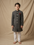 Boy wearing charcoal black machine embroidered floral vine cotton indo western kurta with off-white pajama front view