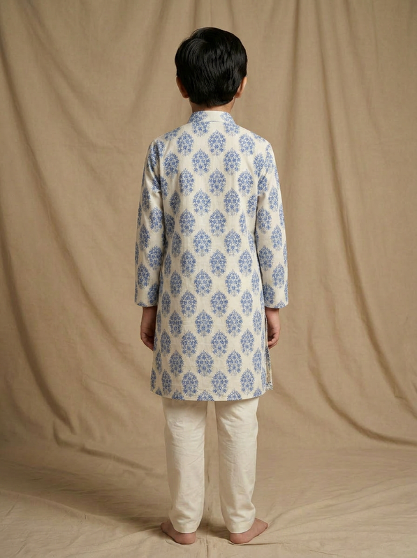 Boy wearing white blue floral medallion hand block printed indo western kurta with off-white pajama back view