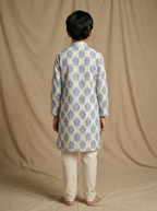 Boy wearing white blue floral medallion hand block printed indo western kurta with off-white pajama back view