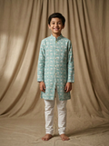 Boy wearing aqua white floral lotus hand block printed indo western kurta with off-white pajama front view