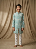 Boy wearing aqua white floral lotus hand block printed indo western kurta with off-white pajama front view