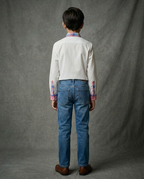 Boy wearing off white cotton shirt with contrast multicolour plaid collar and cuffs back view