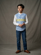 Boy wearing white cotton patch shirt with blue and yellow geometric maze print panels and mandarin collar front view