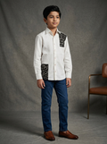 Boy wearing white cotton shirt with black abstract print shoulder panel and patch pocket panel front view