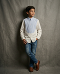 Boy wearing white cotton shirt with contrast blue bib panel and mandarin collar front view