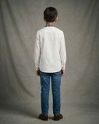 Boy wearing white cotton shirt with contrast blue brown tartan plaid bib panel and mandarin collar back view