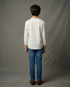 Boy wearing white cotton shirt with contrast mustard floral printed collar and cuffs back view