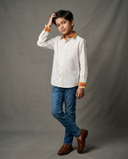 Boy wearing white cotton shirt with contrast mustard floral printed collar and cuffs front view
