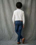 Boy wearing white cotton shirt with contrast charcoal grey striped collar and cuffs back view