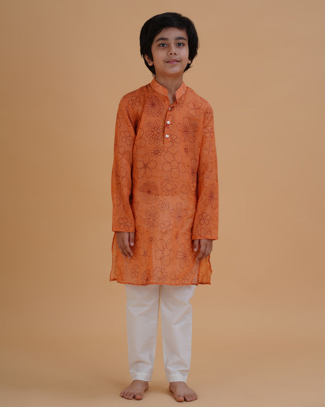 Boy wearing orange boys orange soft organdy floral outline print cotton kurta pajama set front view | NEW AGE CLOTHING
