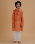 Boy wearing orange boys orange soft organdy floral outline print cotton kurta pajama set front view | NEW AGE CLOTHING