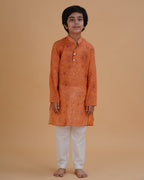 Boy wearing orange boys orange soft organdy floral outline print cotton kurta pajama set front view | NEW AGE CLOTHING